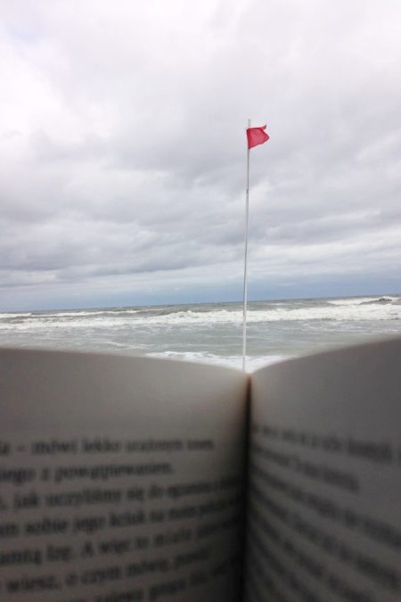 Czerwona flaga, fale, zimno i... ksiażka (widok z kosza plażowego)